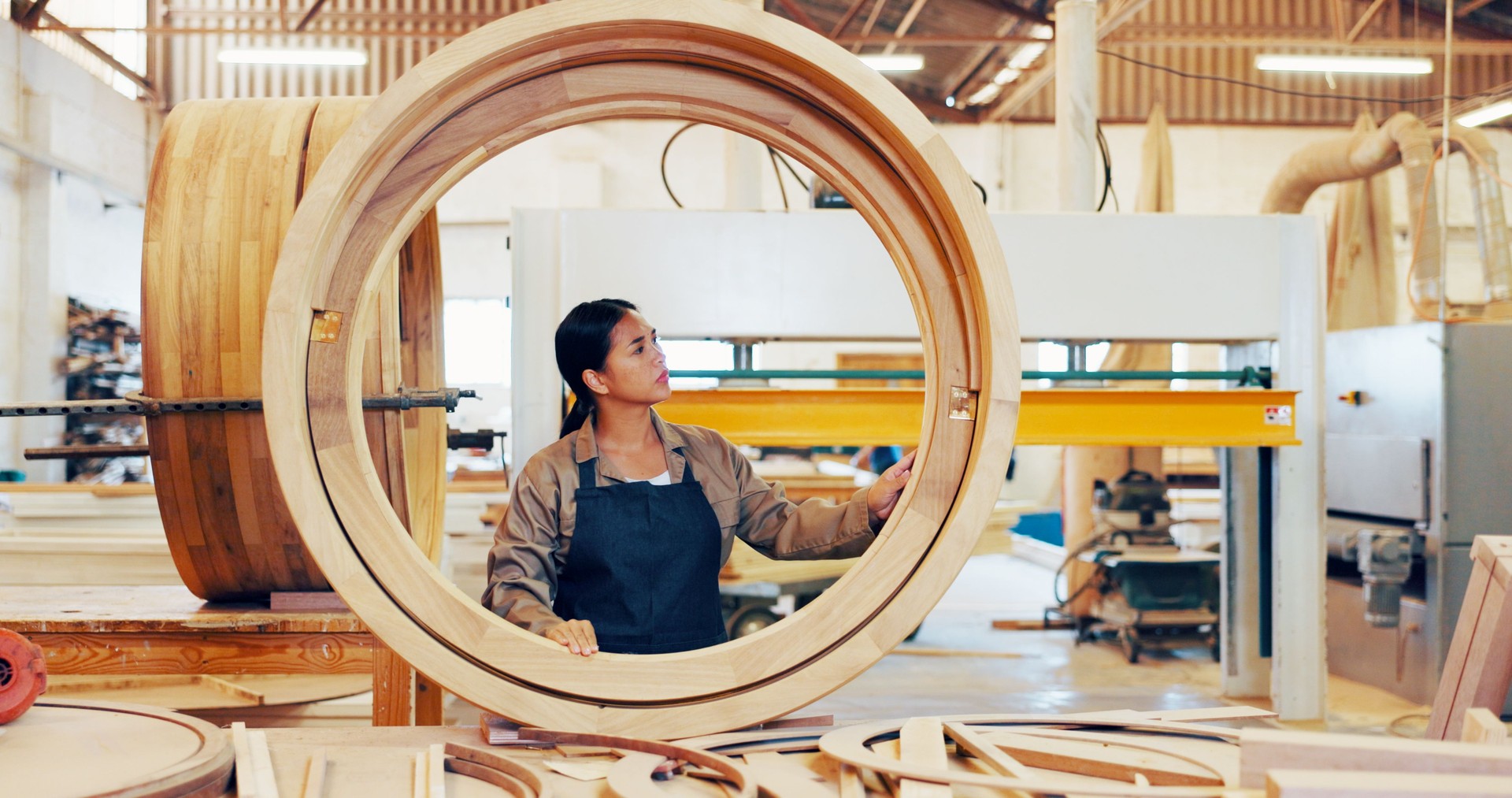 Carpentry, frame and industry with woman in workshop for manufacturing or production process. Circle, creative and design with carpenter in woodworking studio for craftsmanship or manual labor